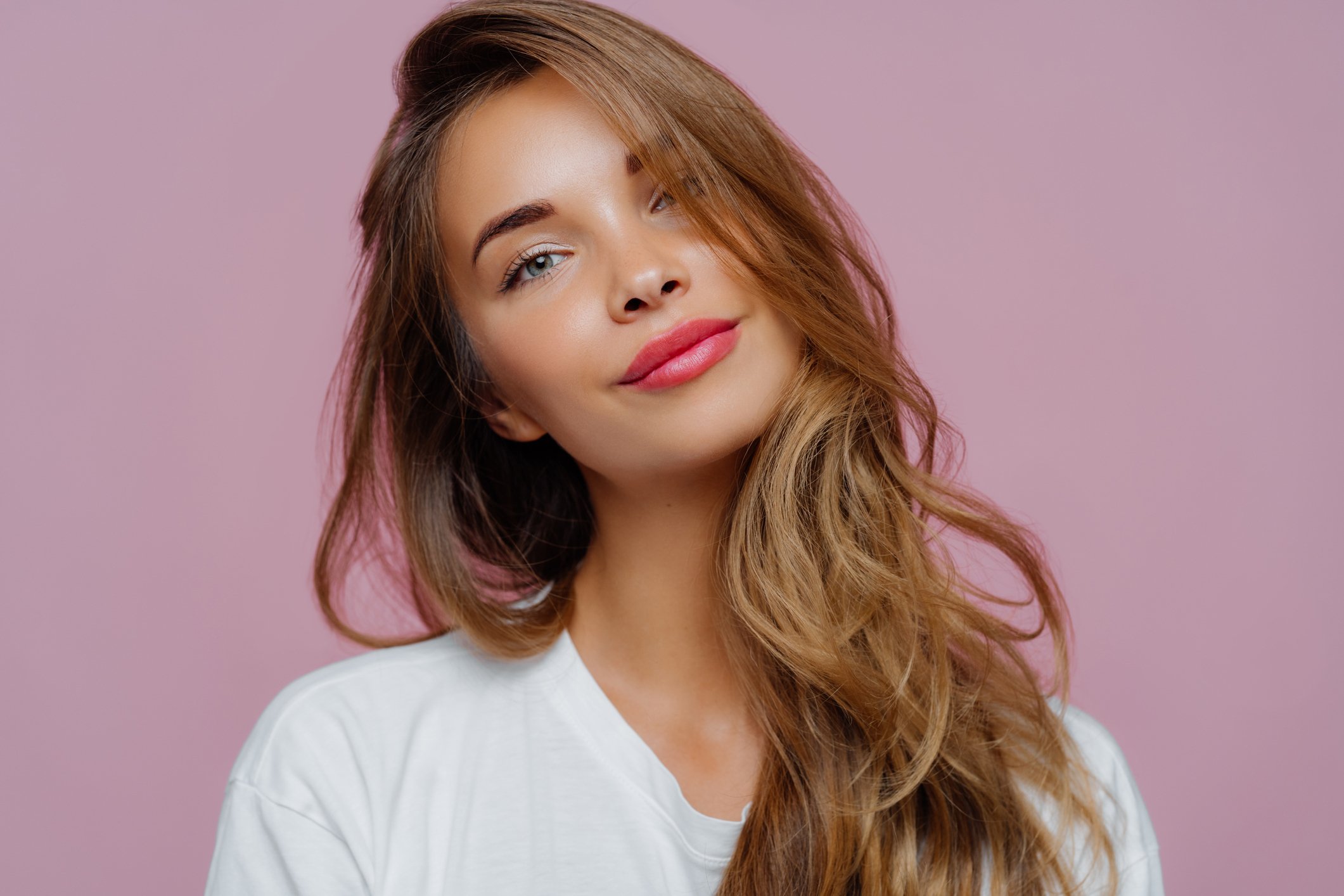 Free Photo  Satisfied curly woman touches face with pleasure stands with  eyes shut holds flexible menstrual cup to insert in vagina during periods  protects from blood leakage isolated on pink wall